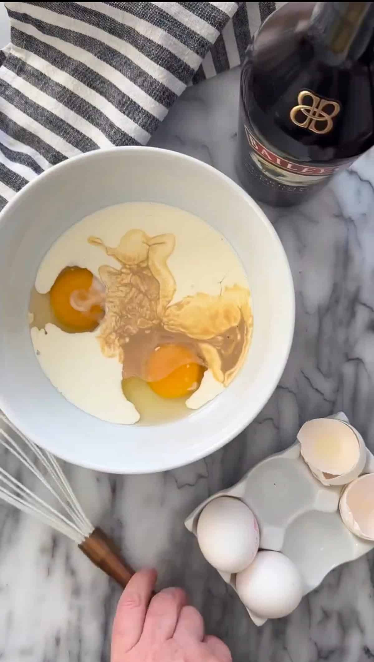 Mixing the ingredients in a bowl for the egg mixture for Baileys french toast.