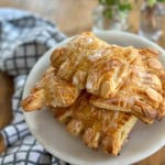 Old fashioned bear claw pastries with almonds on a cake plate.