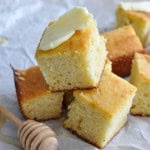 Easy and moist sweet cornbread pieces stacked together and spread with butter.
