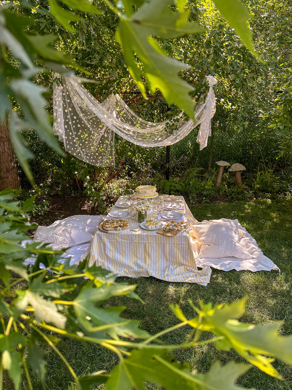A daisy themed party set up in the garden with a canopy.