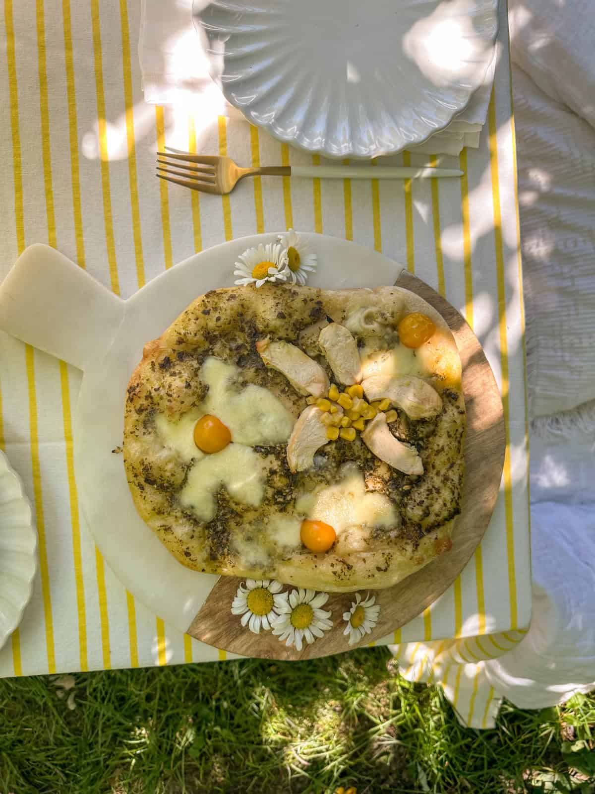 Daisy picnic with pesto sauce, and bocaccini cheese, yellow tomato, corn, and chicken flowers.