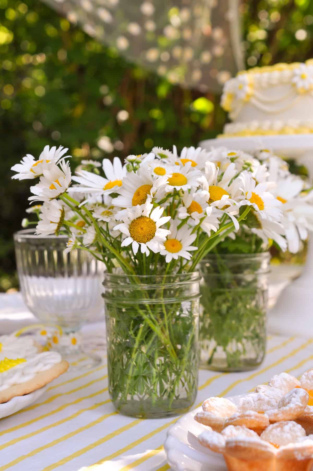 Simple daisy flower arrangments in mini mason jars.