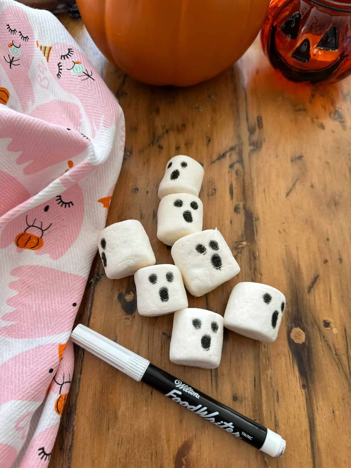 Making ghost marshmallows with an edible food marker.