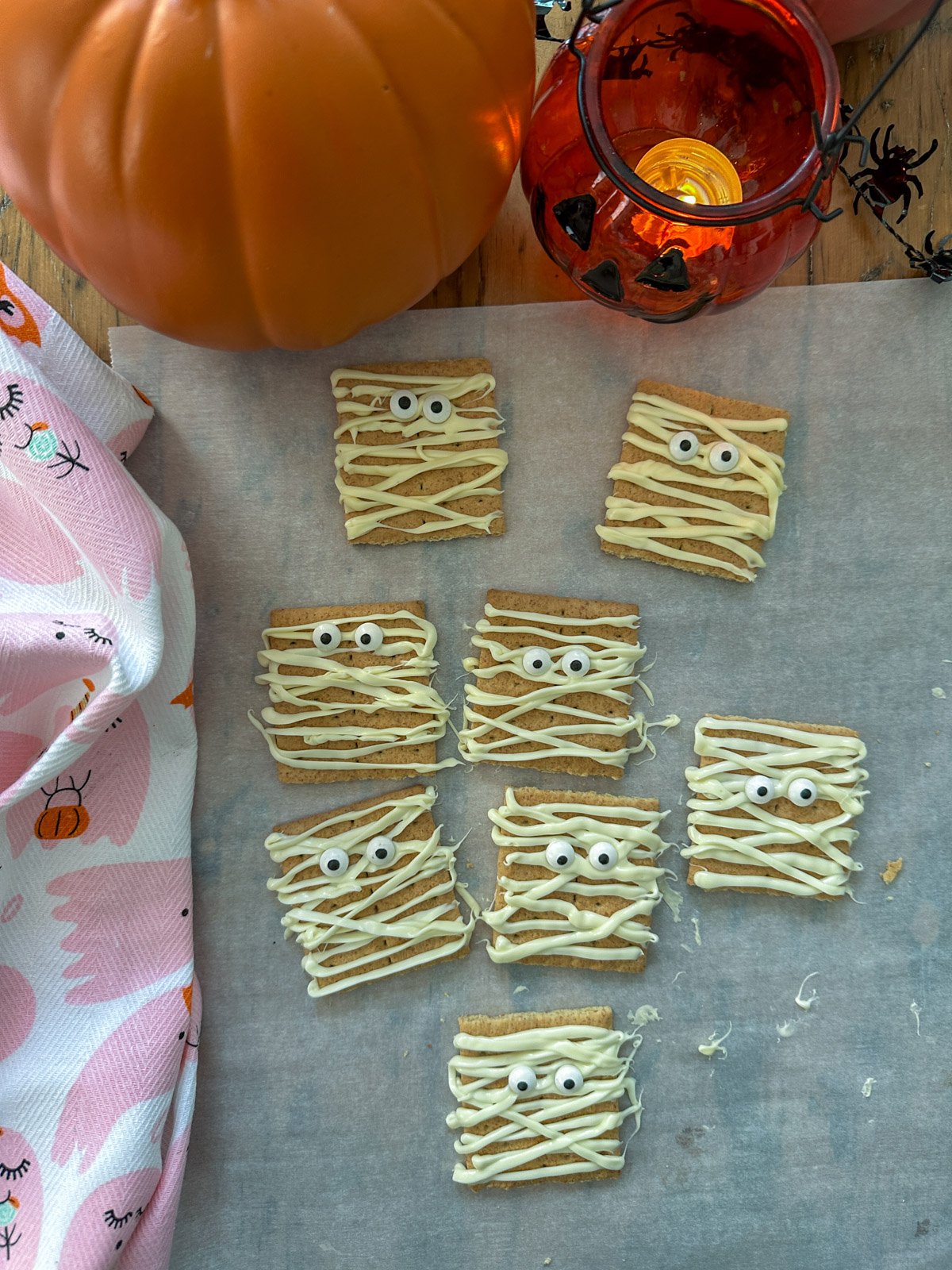 Halloween mummy cookies made with white chocoalte, graham crackers, and candy eyes.