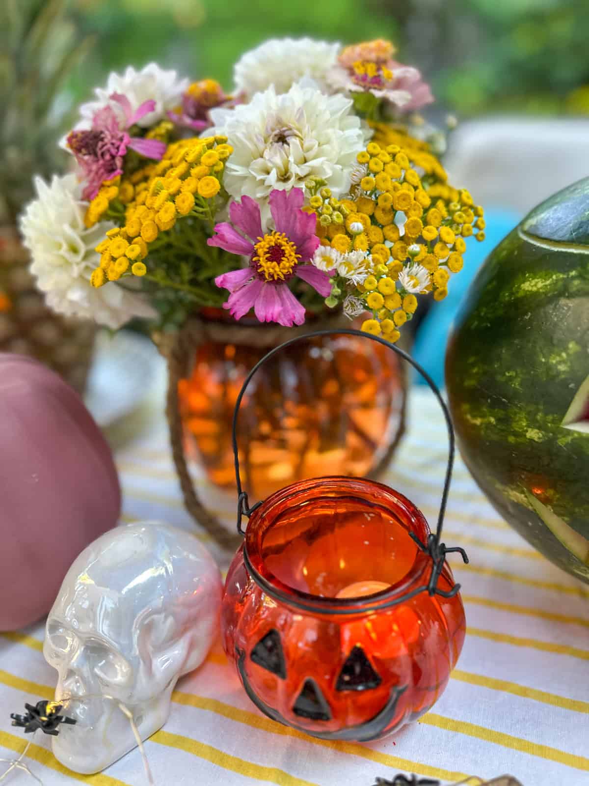 Summerween flower centrepiece with garden flowers in a pumpkin vase.