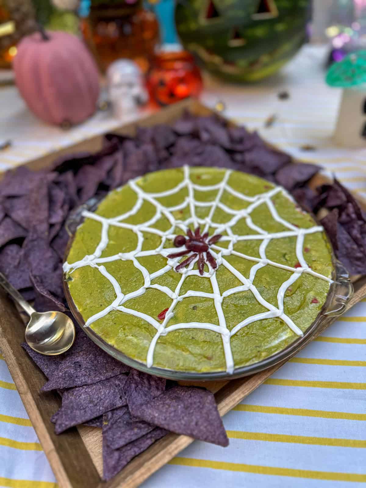 Halloween 7 layer dip with a sour cream spiders web and black olive spider.