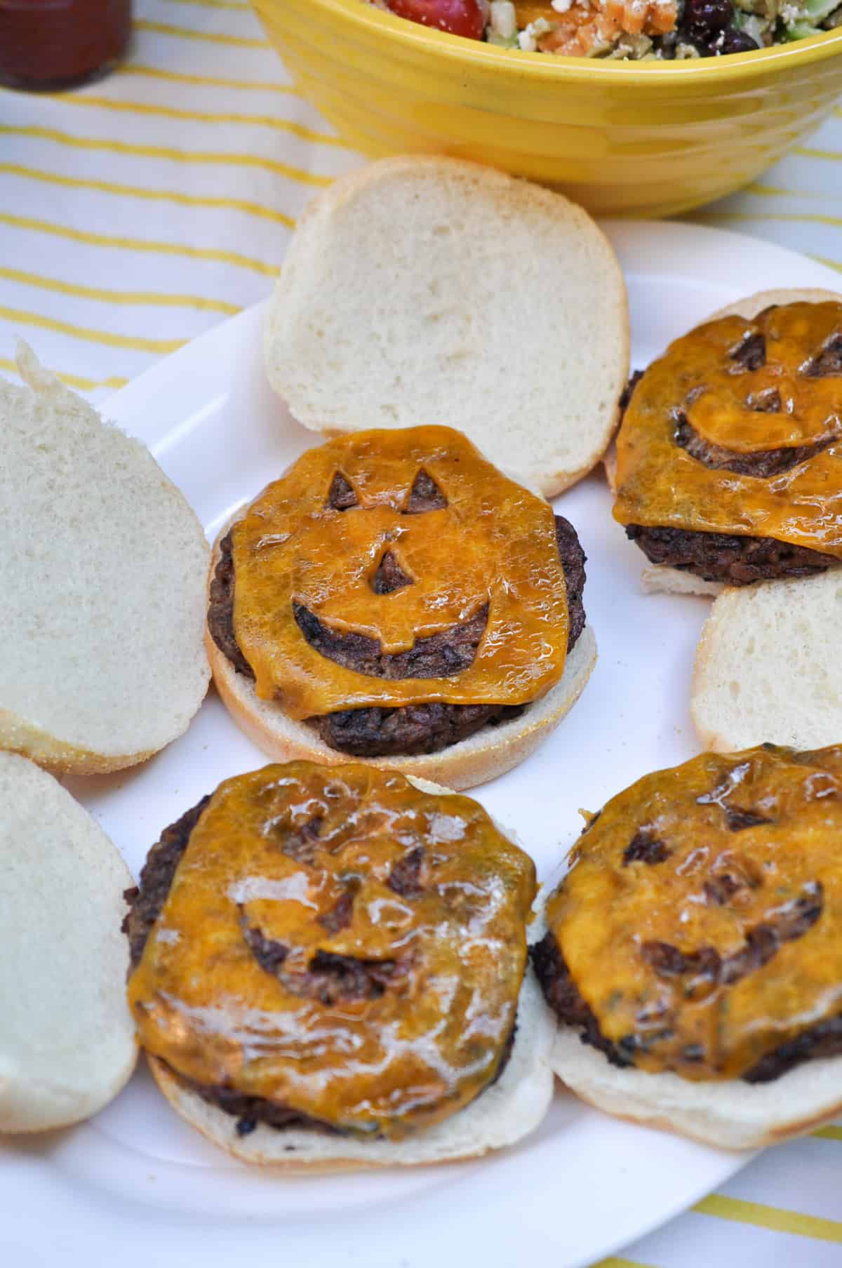 Halloween cheese burgers with jack-lantern faces.