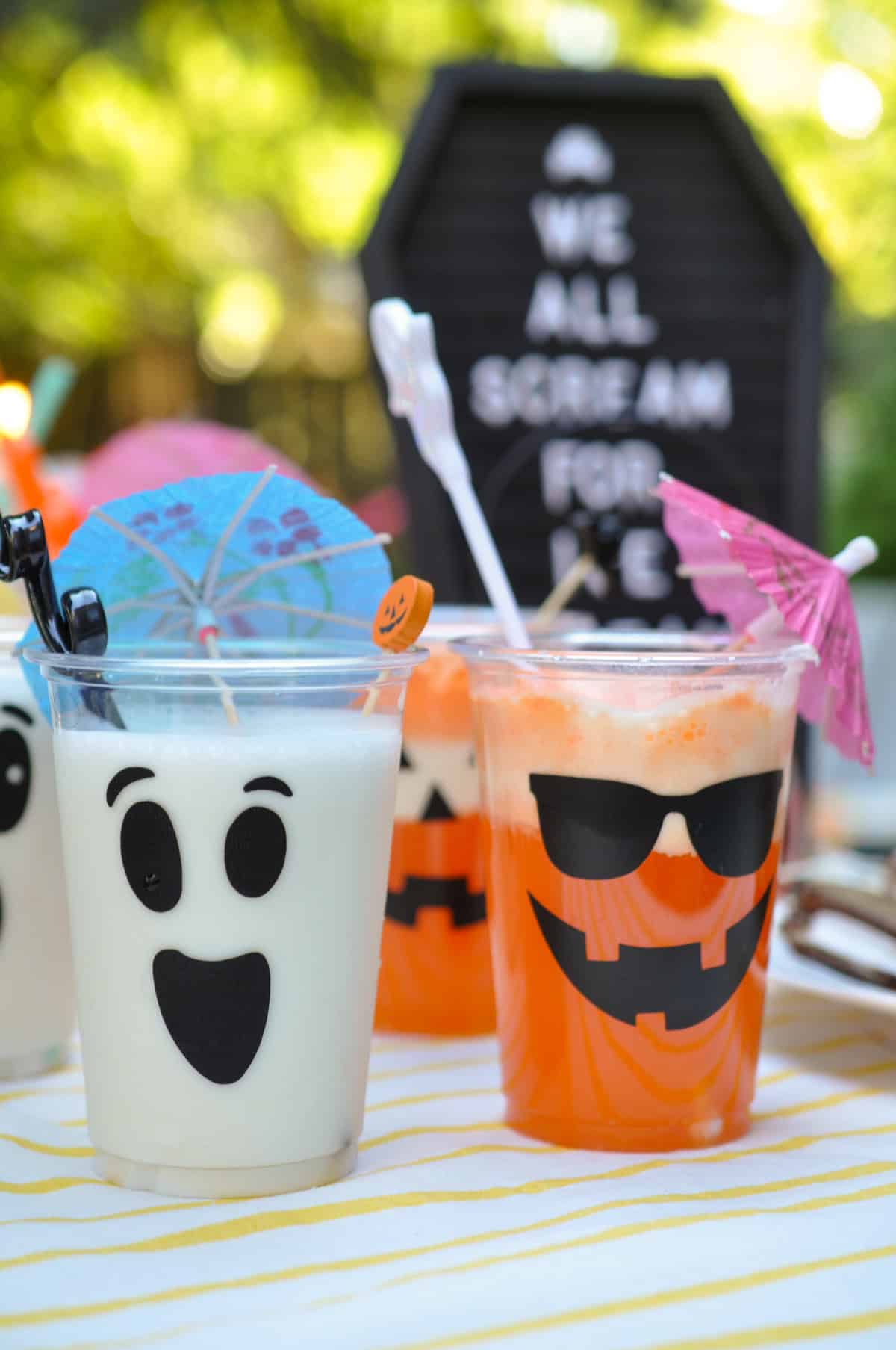 Summerween drinks including coconut milkshakes in ghost face cups, and orange floats in jack-o-lantern cups.