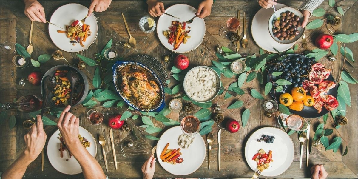Thanksgiving tablescape with turkey, plates, and glasses.