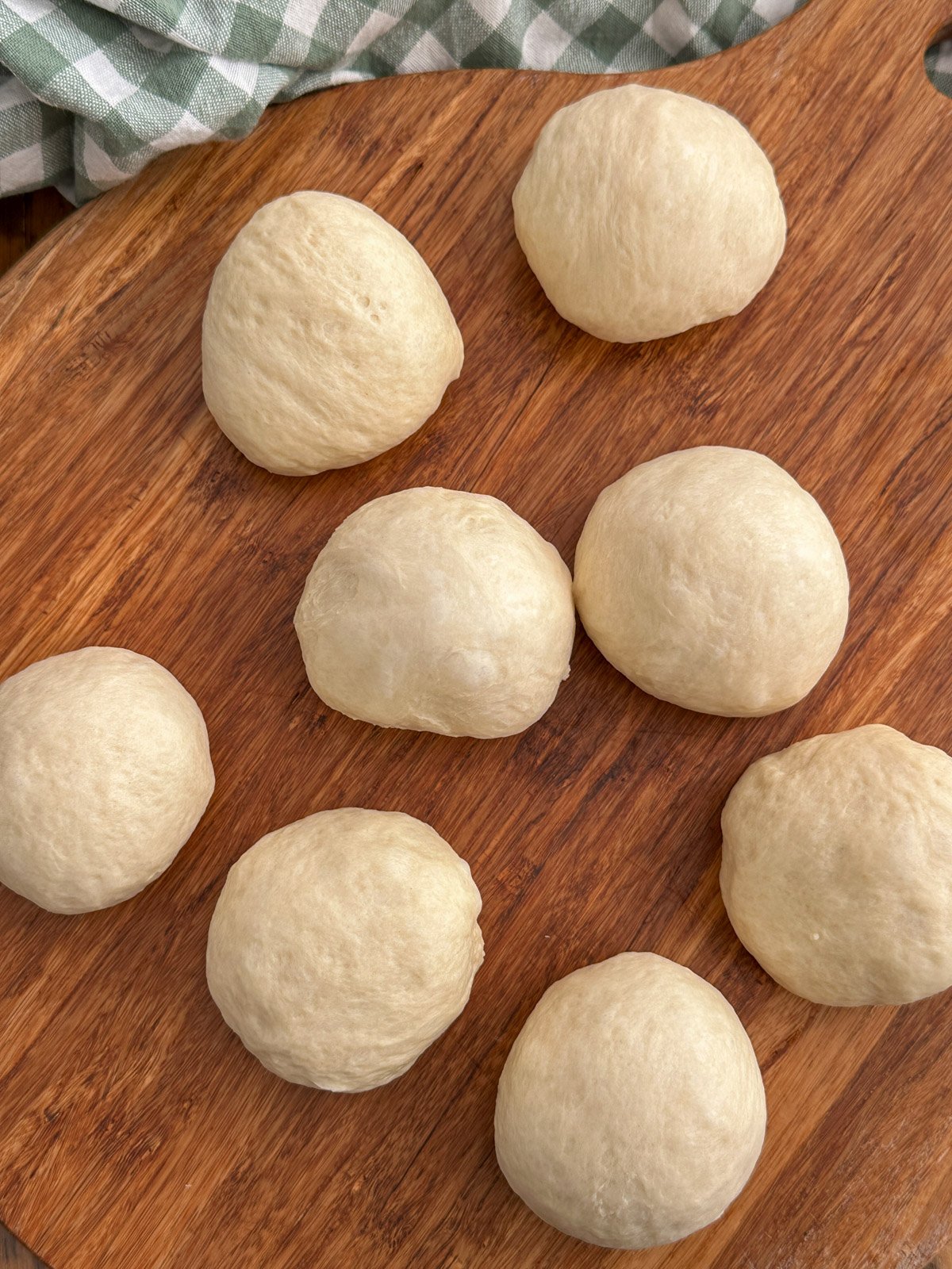 Dinner roll dough shaped into 8 equal balls.