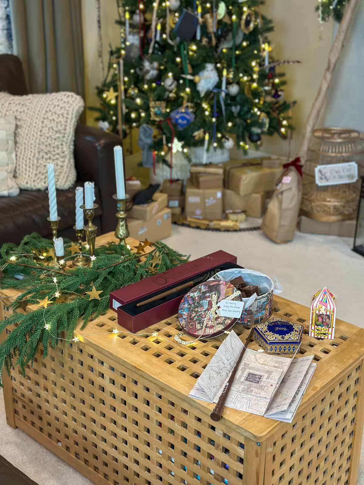 Harry Potter Christmas decorations on a coffee table with wand, chocolate frogs, and Marauder's Map for themed holiday decor ideas.