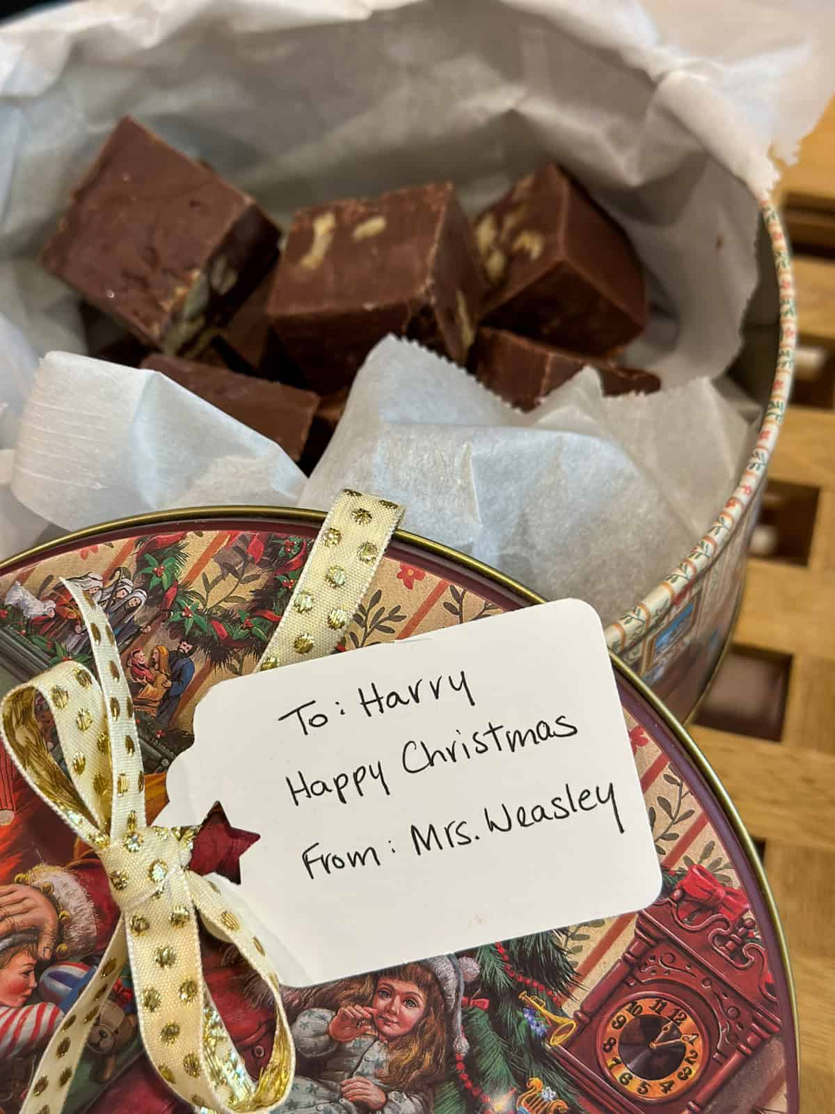 Tin of Mrs. Weasley's Christmas fudge for Harry Potter with a gift tag.