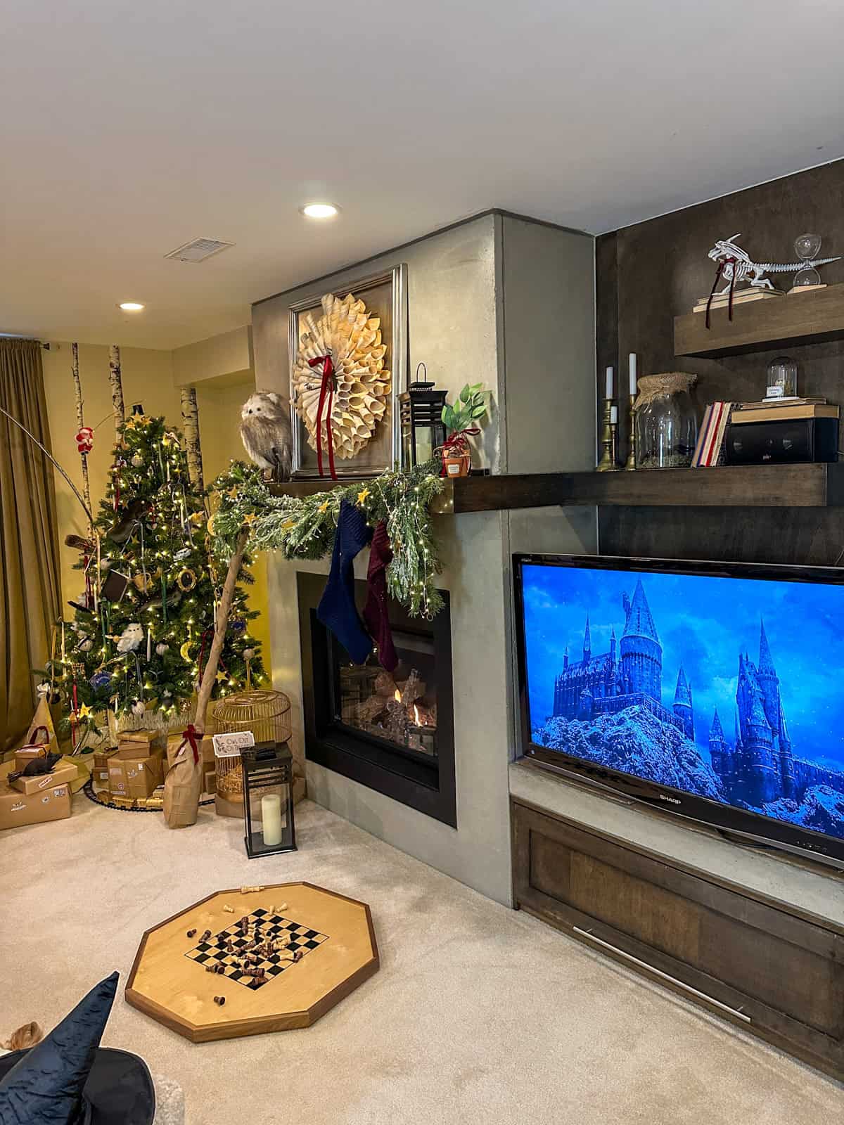Harry Potter Christmas room with tree, mantel, stockings, and Hogwarts on TV for complete holiday decorating ideas.