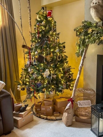 DIY Harry Potter Christmas tree with homemade ornaments, 7 Horcruxes, and motorized Santa tree topper in cozy living room.