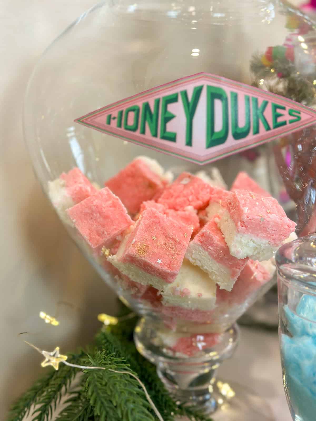 Homemade coconut ice in a large glass jar on a Harry Potter Honeydukes candy cart.