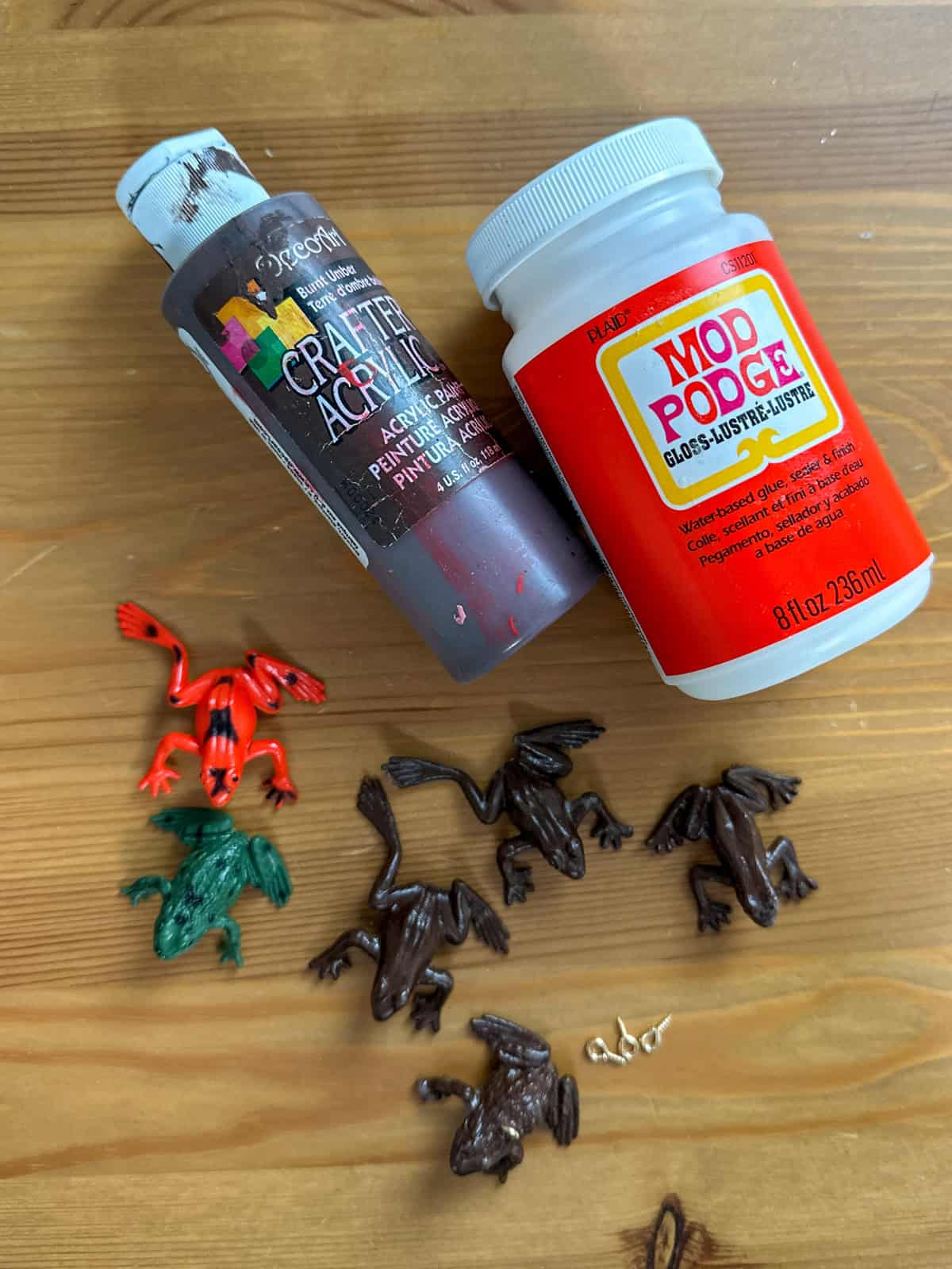 Toy frog, brown craft paint, and mod podge supplies to make chocolate frog ornaments for a Harry Potter themed Christmas tree.