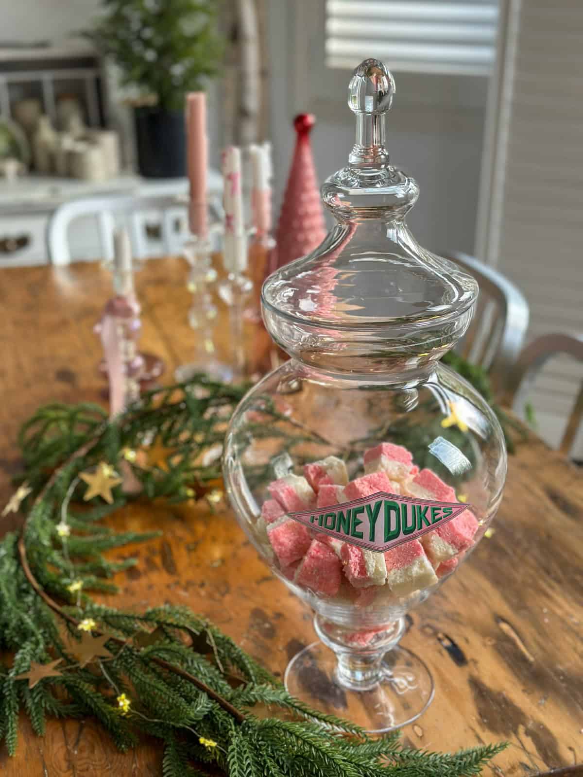 Homemade coconut ice cut into squares, and in a large glasse Honeydukes jar.