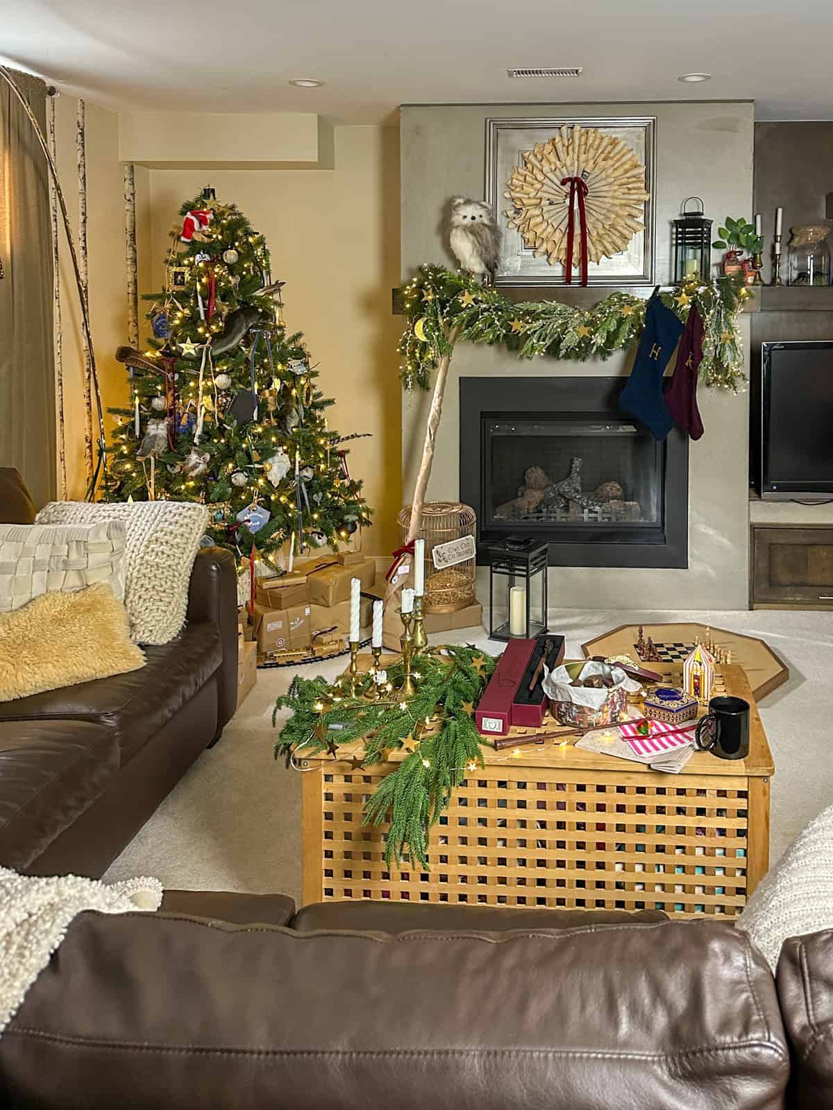 Harry Potter Christmas living room with decorated tree, Weasley stockings on mantel, and Honeydukes candy on coffee table.