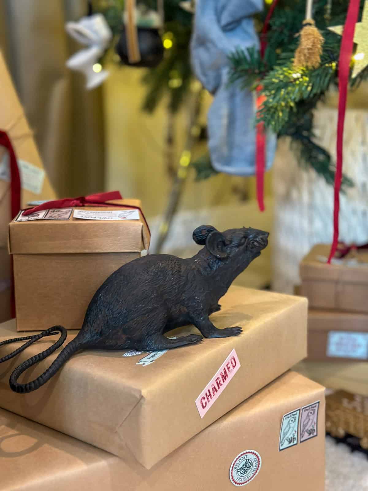 Scabbers rat decoration on owl post packages under Harry Potter Christmas tree for themed holiday decor.