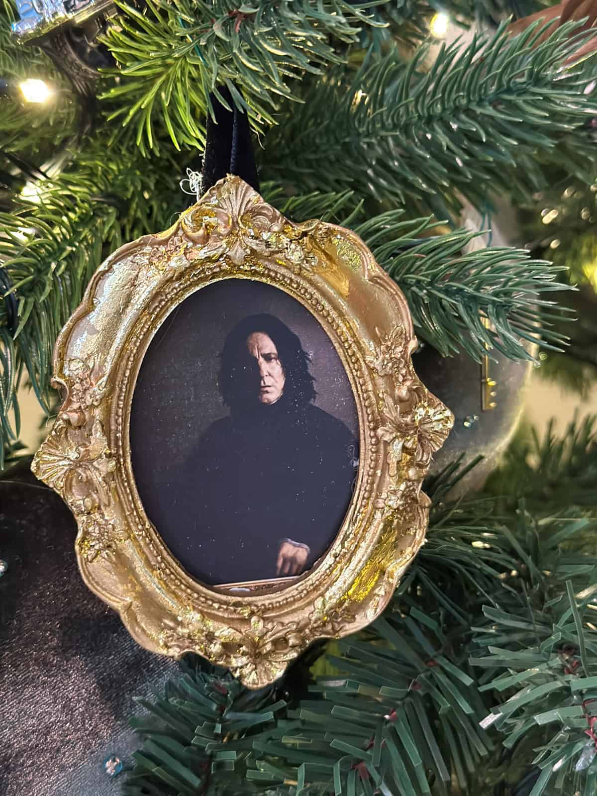 Professor Snape portrait ornament in ornate gold frame with gold leaf detail hanging on Harry Potter Christmas tree.