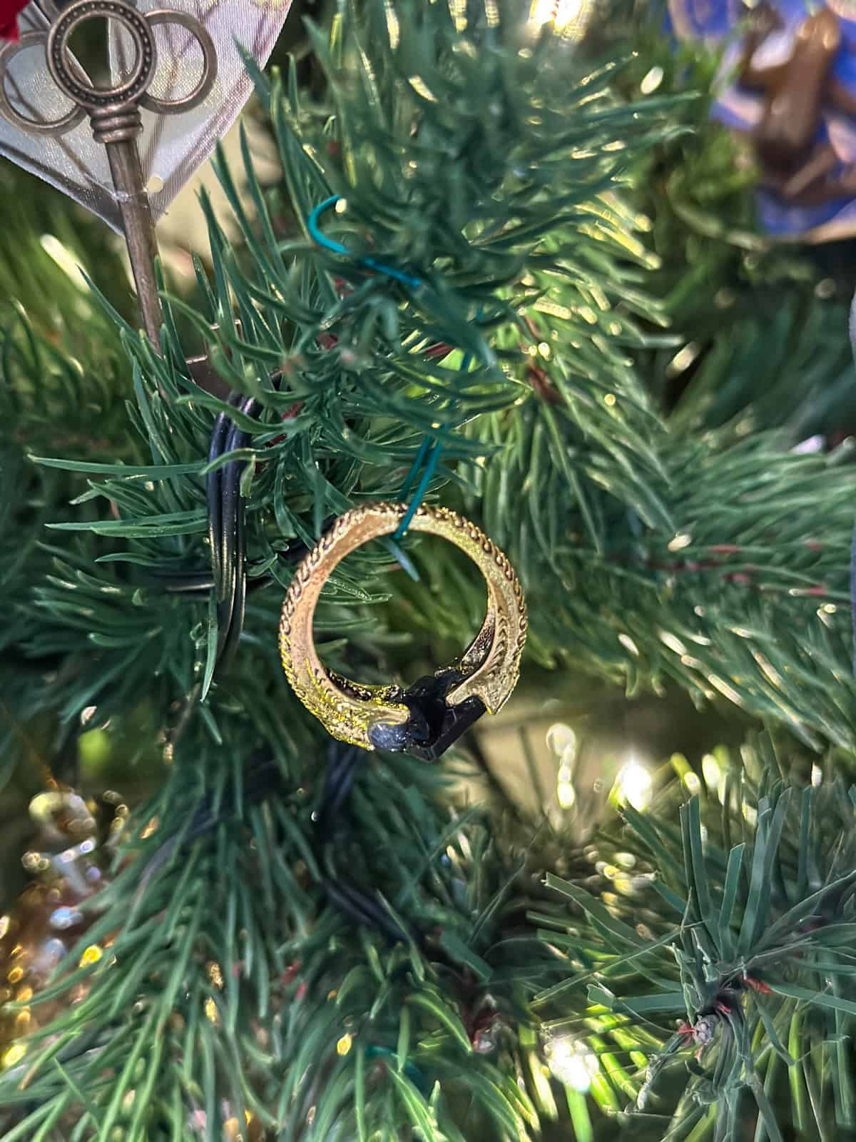 Marvolo Gaunt ring Horcrux ornament with gold serpent design and black stone hanging on Harry Potter Christmas tree.
