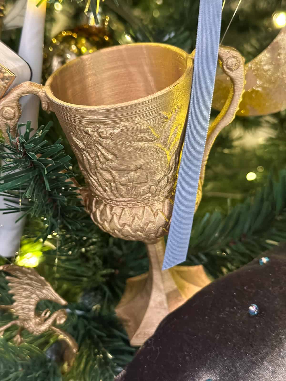 3D printed Hufflepuff cup Horcrux ornament spray painted gold hanging on Harry Potter Christmas tree.