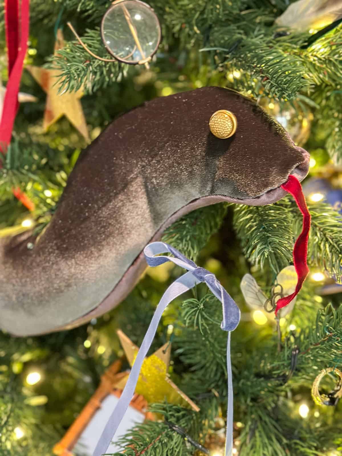 DIY Nagini snake ornament made from green and brown velvet, hanging on Harry Potter Christmas tree.