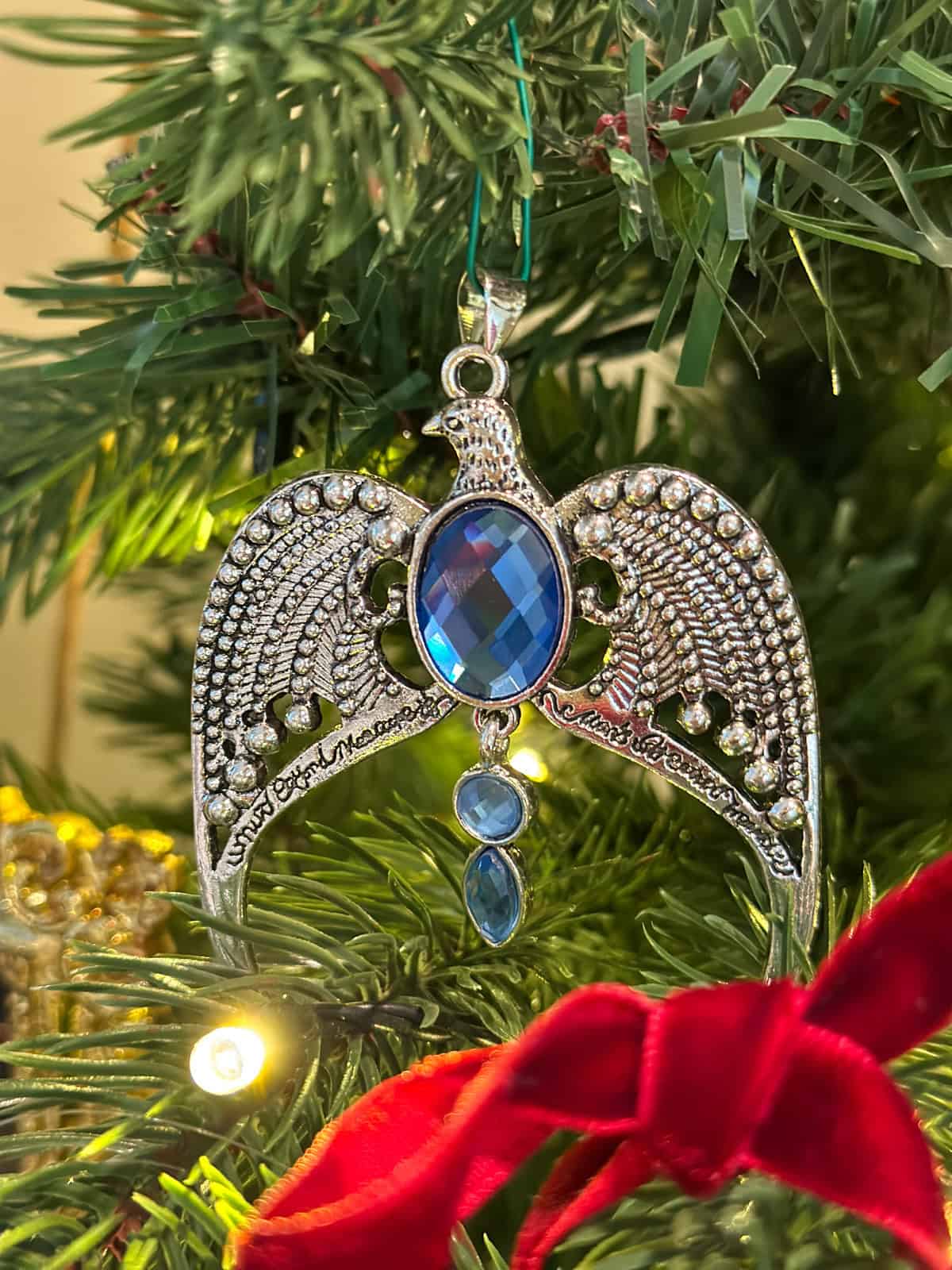 Silver Ravenclaw diadem Horcrux ornament with blue gemstones and eagle wings on Harry Potter Christmas tree.