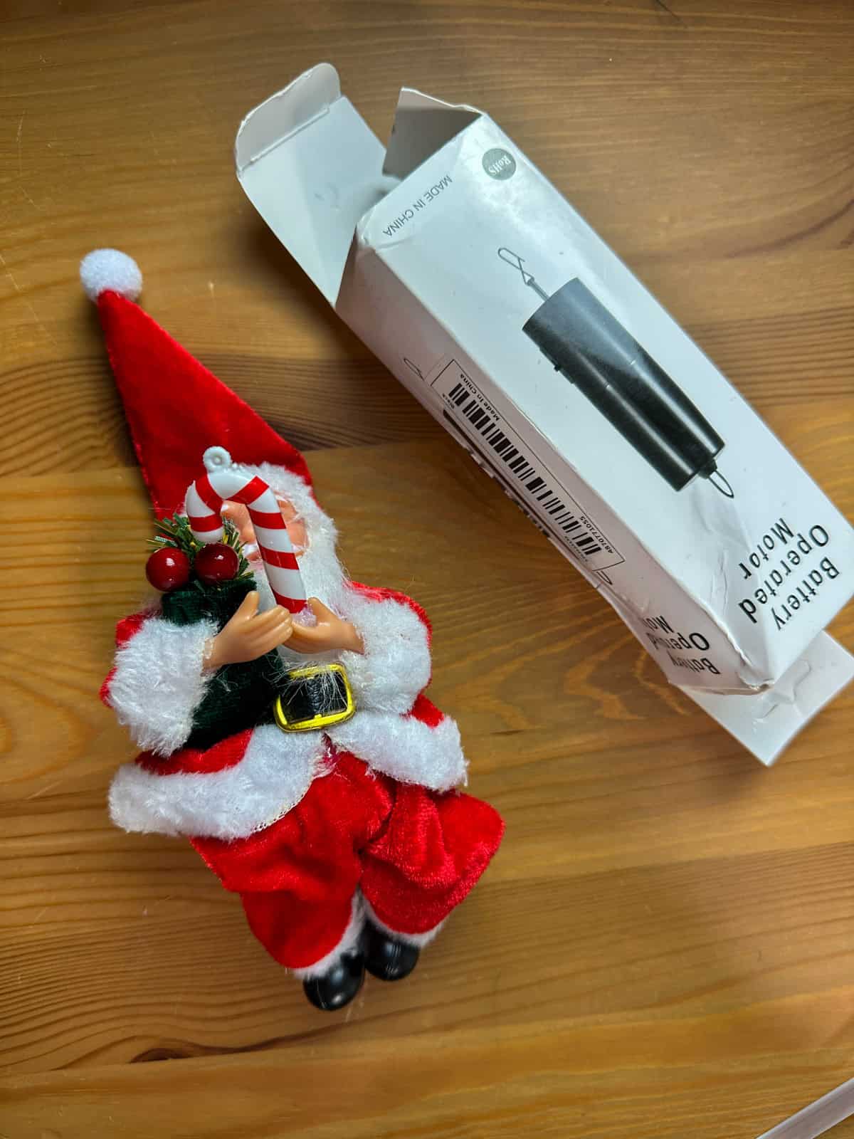 Santa figurine with candy cane and disco ball motor for DIY flying tree topper on Harry Potter Christmas tree.