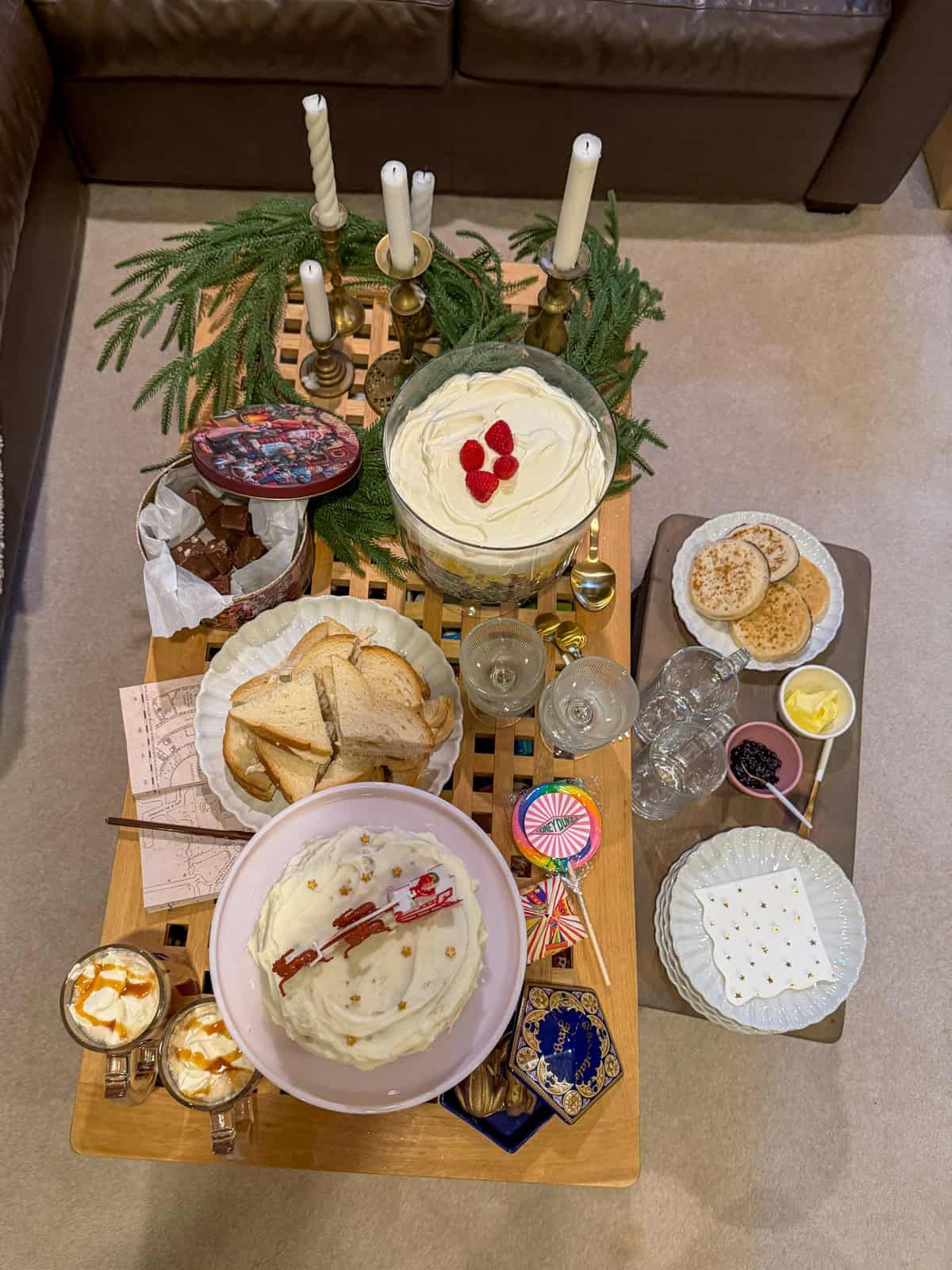 Harry Potter Christmas party food ideas, table with turkey sandwiches, trifle, Christmas cake, crumpets, and butterbeer.
