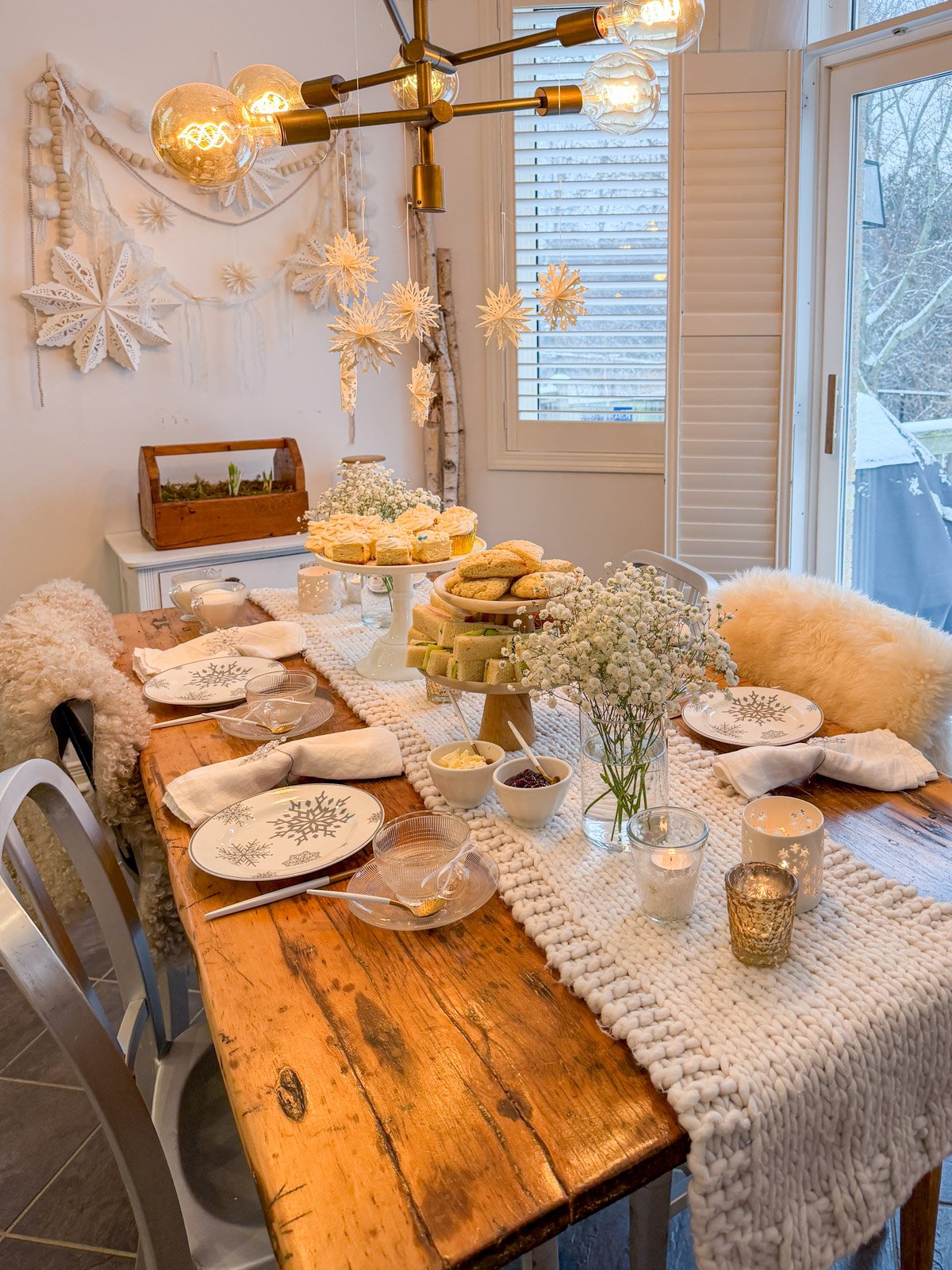 Winter tea party with snow themed decorations including paper snowflakes.