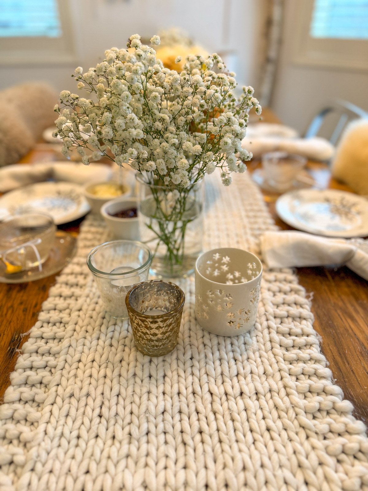 Winter tea party centrepieces of snow-themed baby's breath and votive candles.