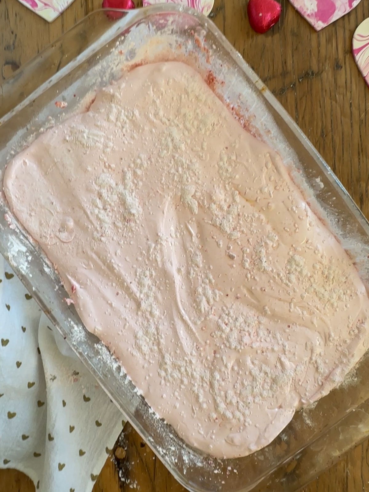 Pink strawberry marshmallow mixture spread in 9x13 pan dusted with coating.