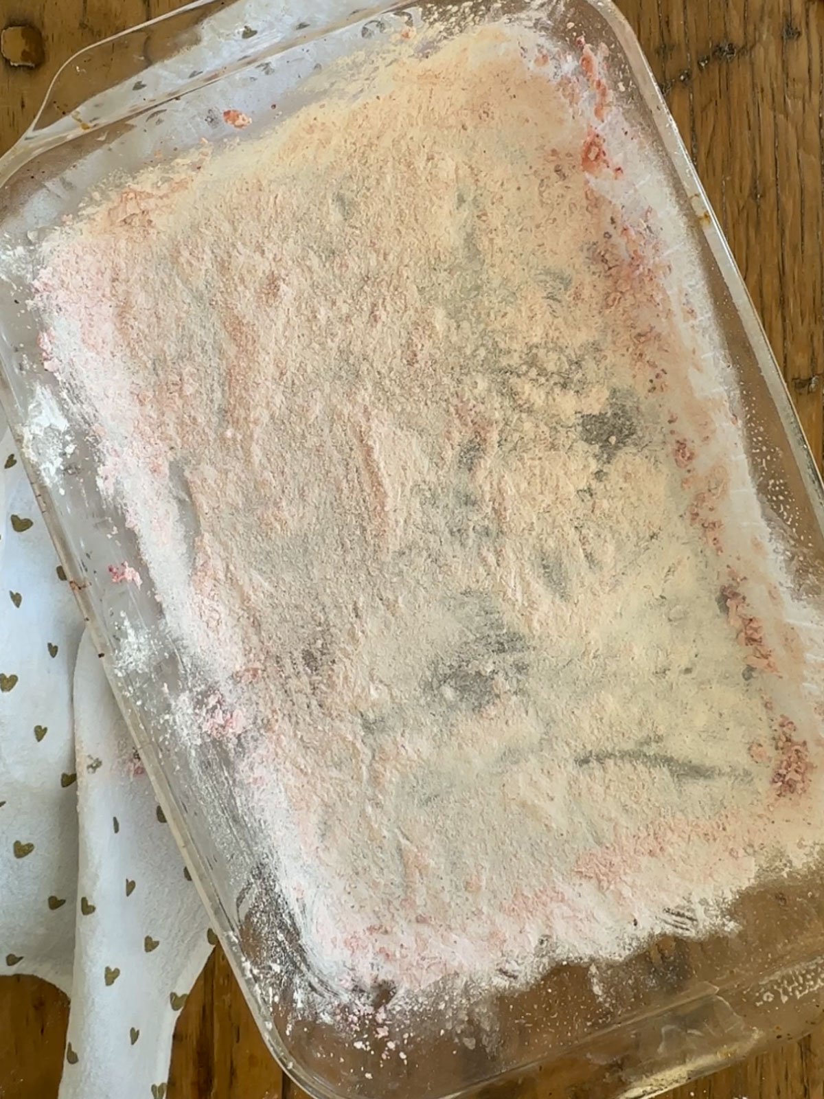 Prepared pan for homemade strawberry marshmallows, sprayed with non-stick cooking spray and coated in a mixture of powdered freeze-dried strawberries, cornstarch, and powdered sugar.