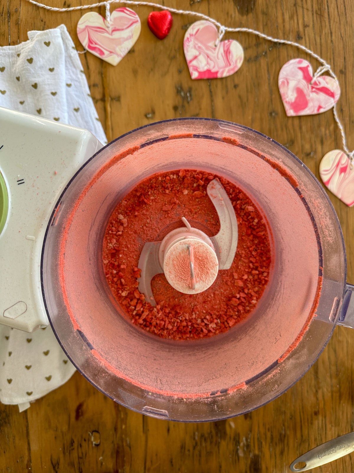 Freeze-dried strawberries processed into powder in food processor for homemade strawberry marshmallows.