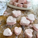 Close up of pink heart-shaped strawberry marshmallows dusted with coating.