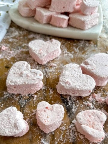Close up of pink heart-shaped strawberry marshmallows dusted with coating.