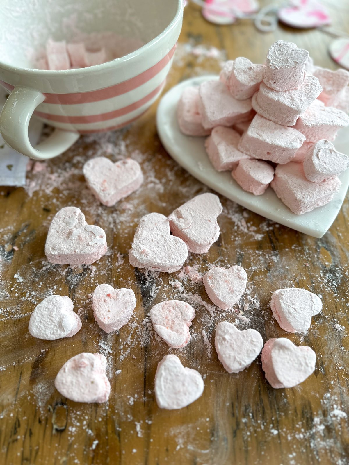 Homemade strawberry marshmallows made with freeze dried strawberries and cut into heart shapes.