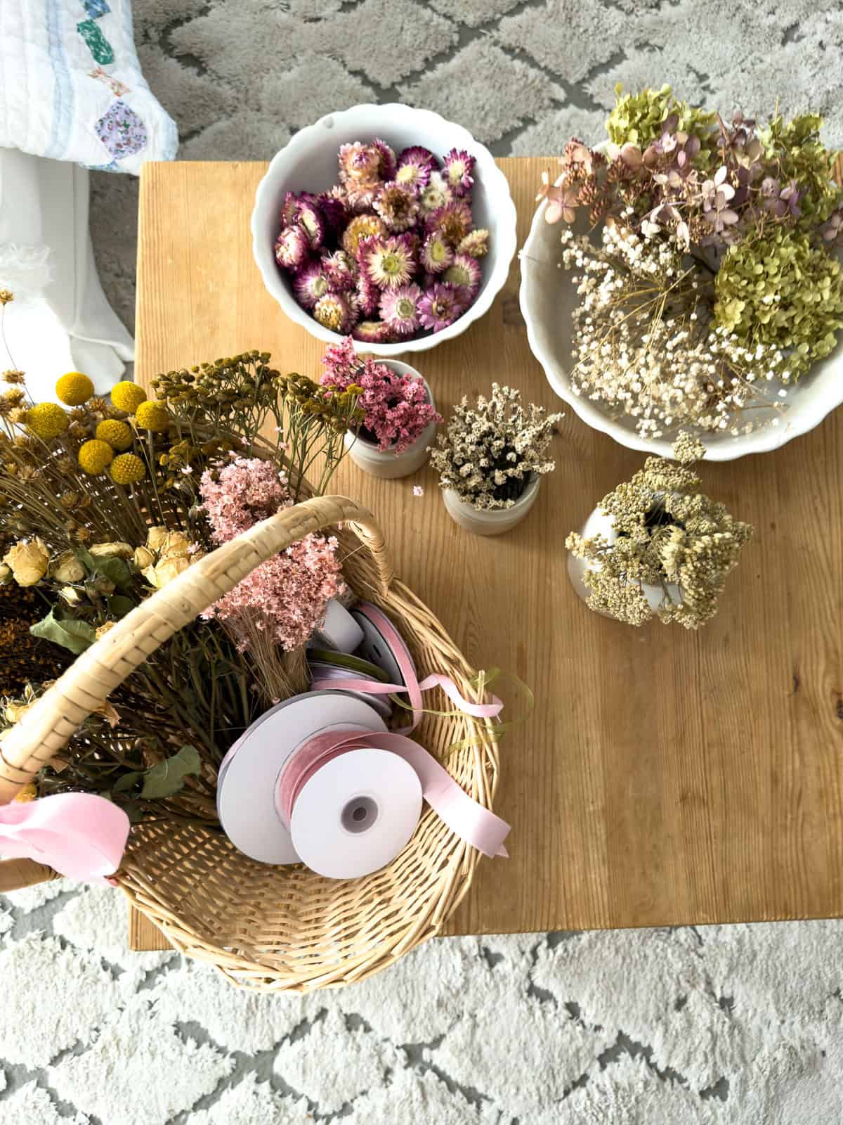 Overhead flat lay of dried flowers including billy balls, lavender and hydrangea for making flower crowns at a Little Women vintage tea party.
