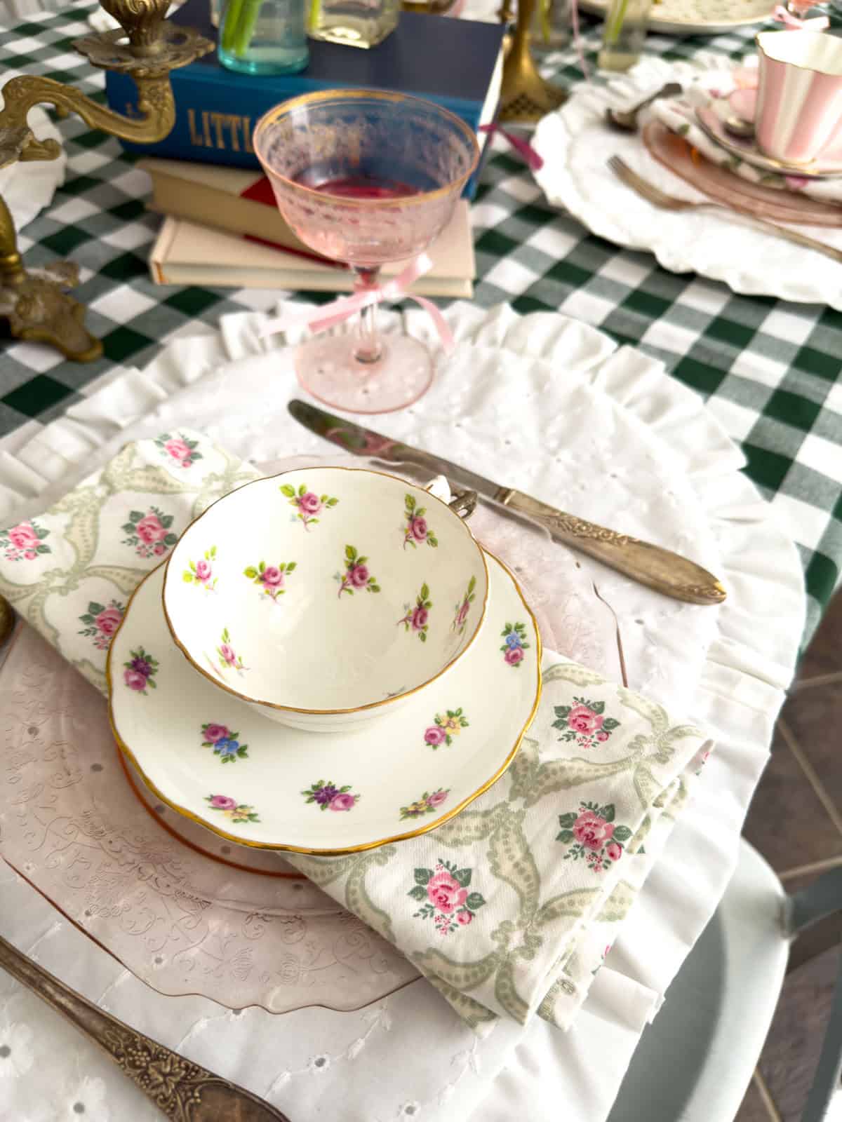 Pink rose vintage teacup beside a Little Women book at a vintage tea party table setting.