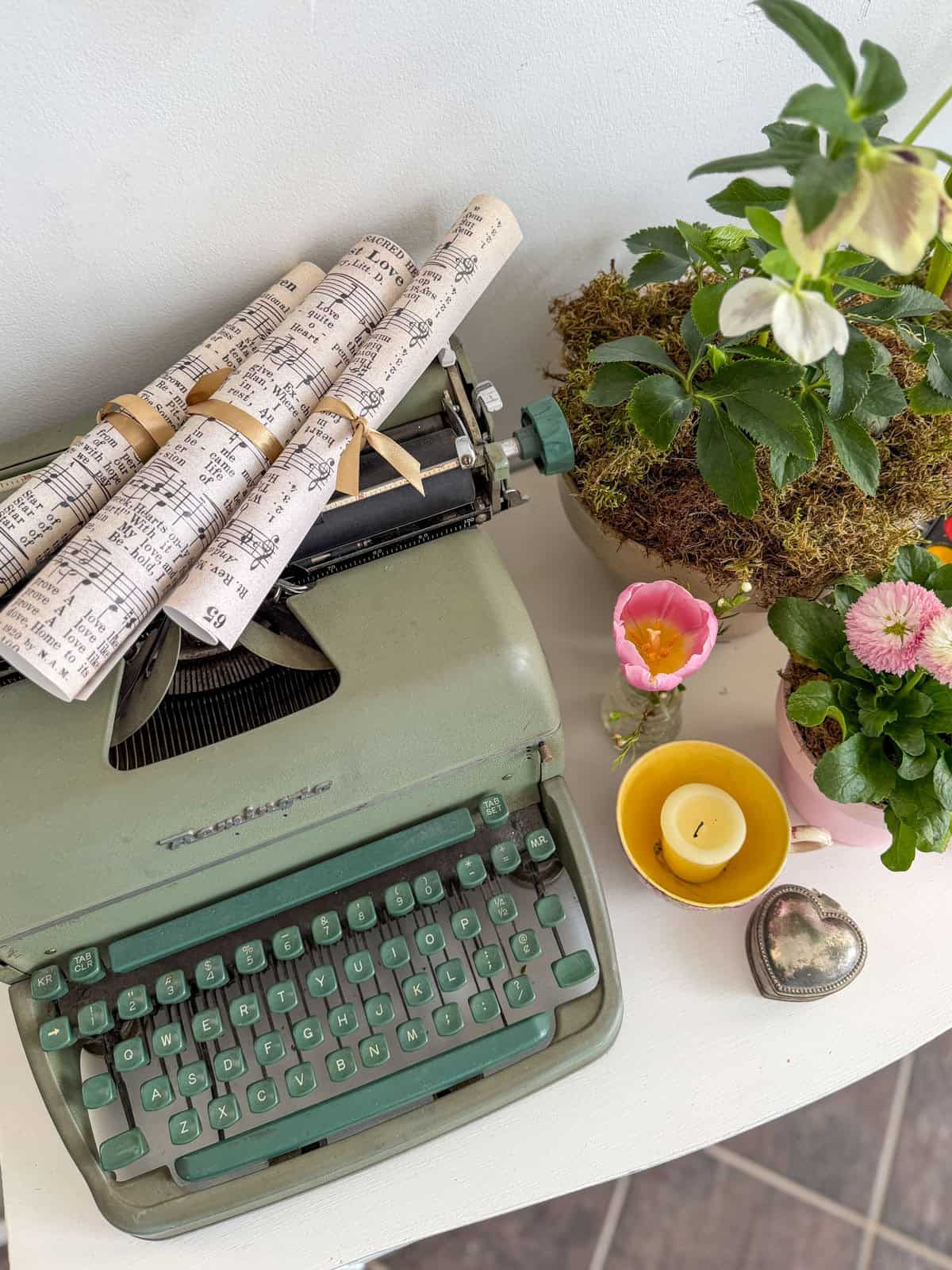 Rolled sheet music tied with ribbon on a vintage typewriter representing Beth March at a Little Women vintage tea party.