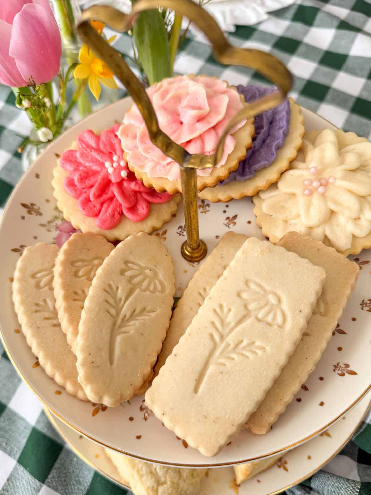 Stamped shortbread cookies with botanical flower imprint on a gold tiered stand with frosted flower sugar cookies at a Little Women vintage tea party.