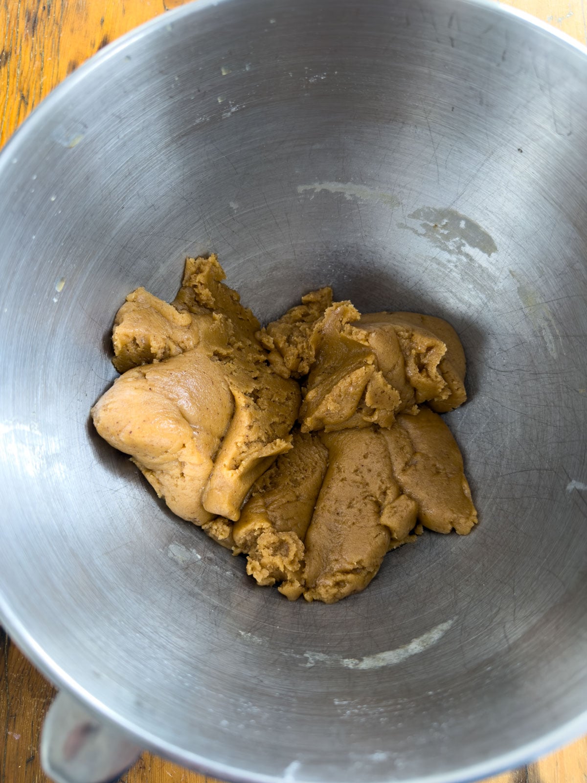 Brown butter cookie dough in a silver mixing bowl before Cadbury mini eggs are folded in.