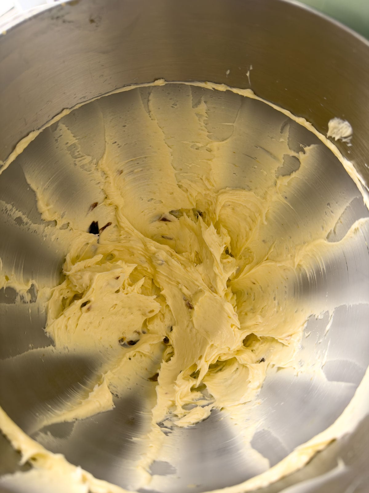 Overhead view of roasted garlic butter fully whipped together in a stainless steel stand mixer bowl.