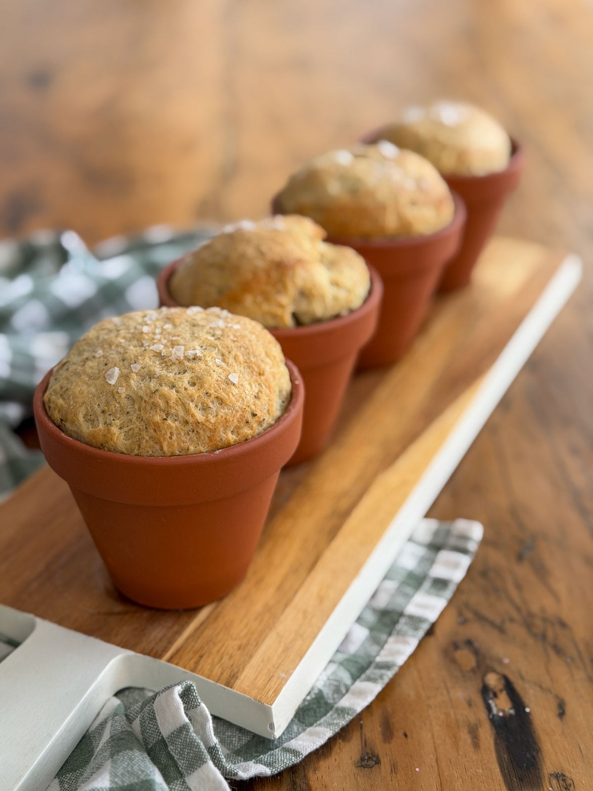 Flower pot bread baked in terracotta pots on a wooden serving board.
