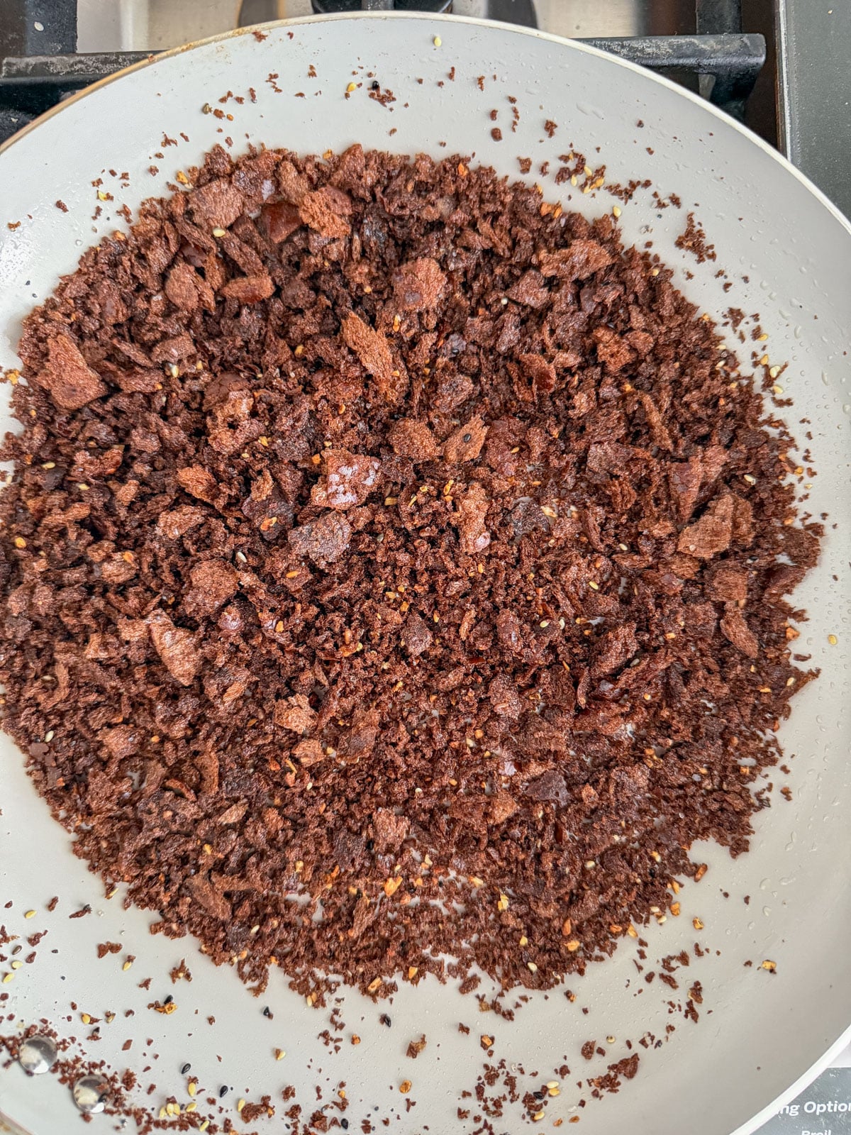 Toasted pumpernickel breadcrumbs with everything bagel seasoning in a skillet on the stovetop.