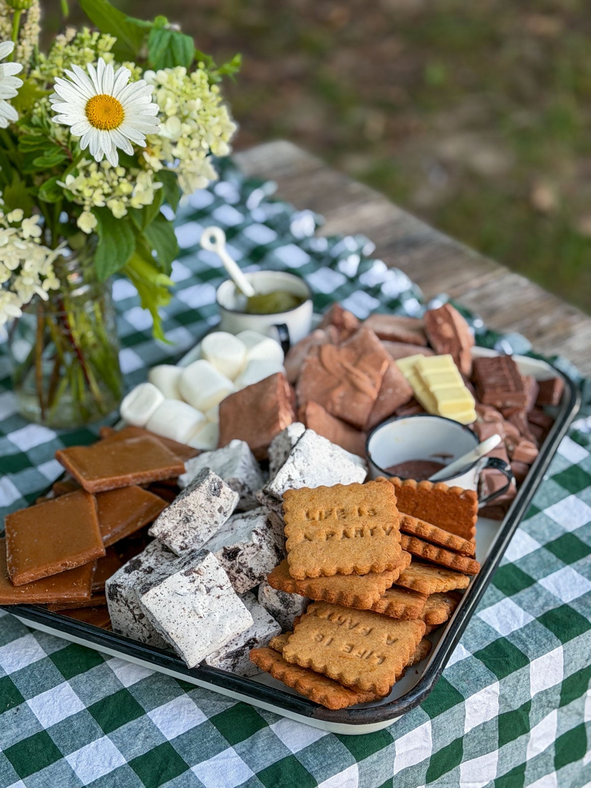S'mores dessert board with homemade marshmallows, graham crackers, and assorted chocolate.