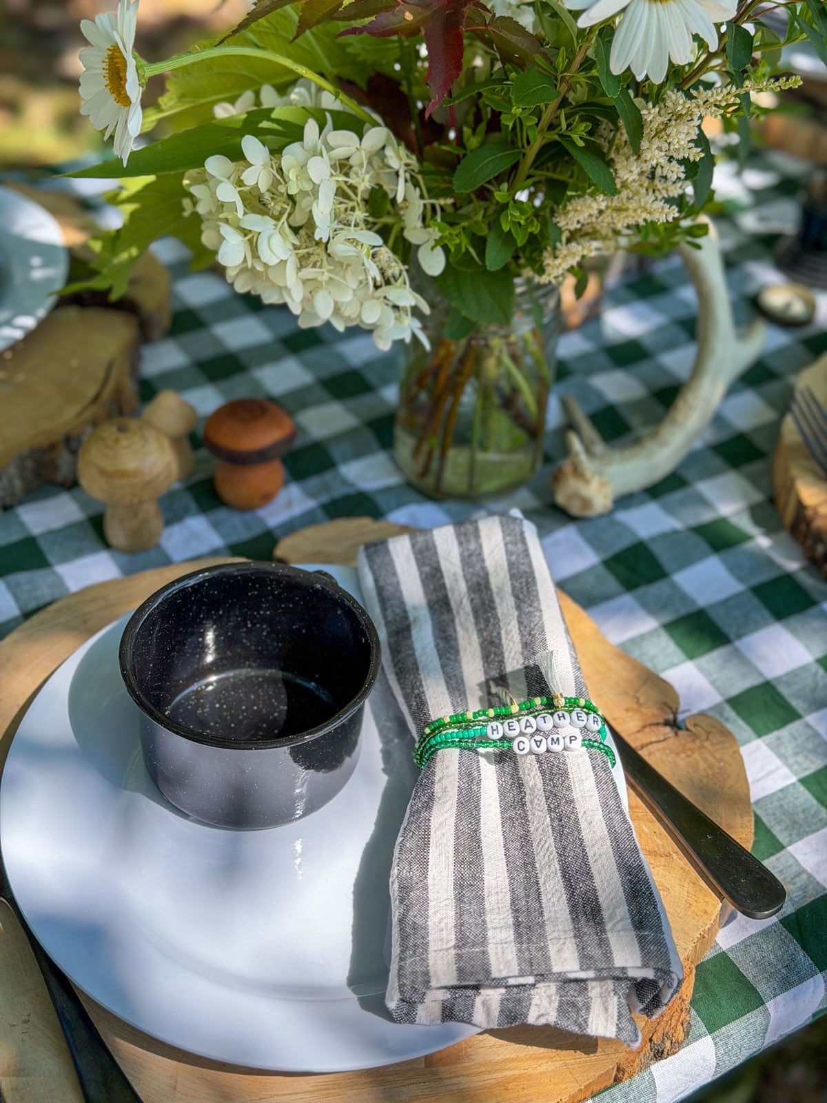 Striped napkin with green beaded Heather Camp friendship bracelet napkin ring.