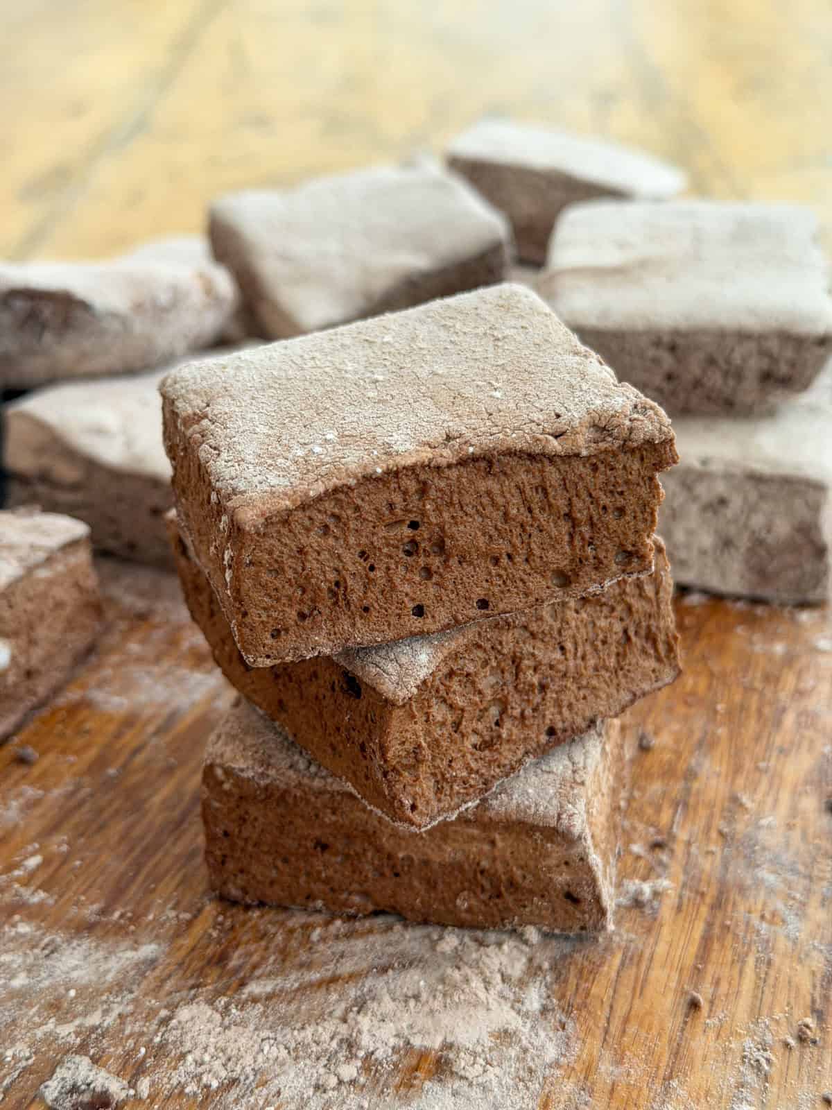 Stack of chocolate marshmallows dusted with cocoa coating.