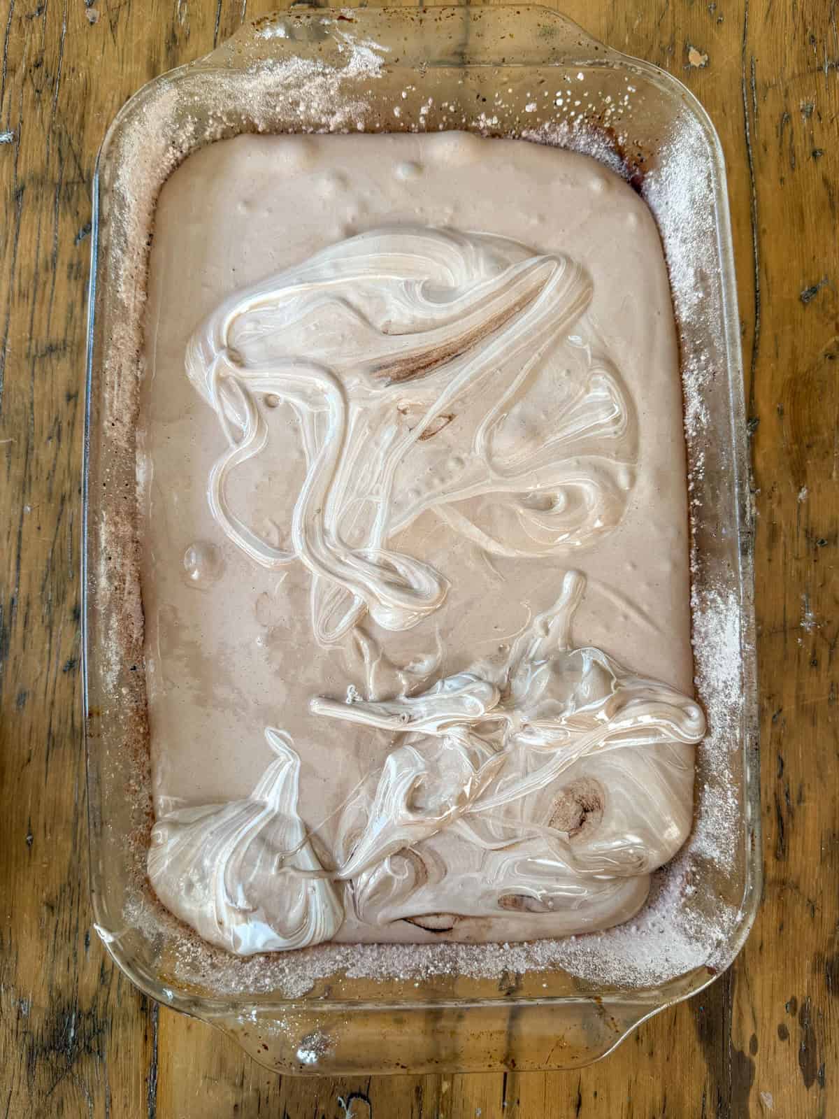 Chocolate marshmallow mixture poured into a dusted pan.